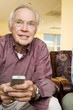 An elderly man using a TV remote control