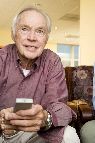 Photo: An elderly man using a TV remote control An elderly man using a TV remote control