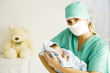 A medical practitioner holding a newborn baby