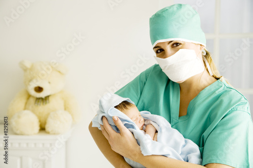 Photo: A medical practitioner holding a newborn baby A medical practitioner holding a newborn baby