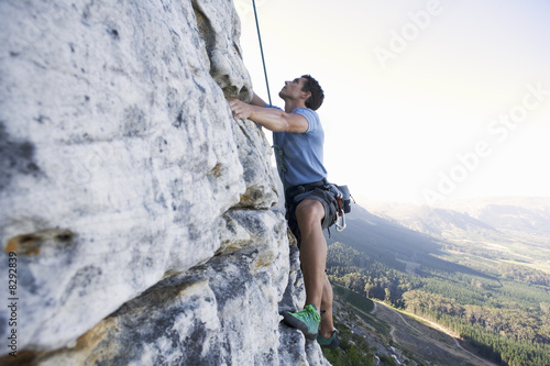 Photo: A climber climbing a rock face A climber climbing a rock face