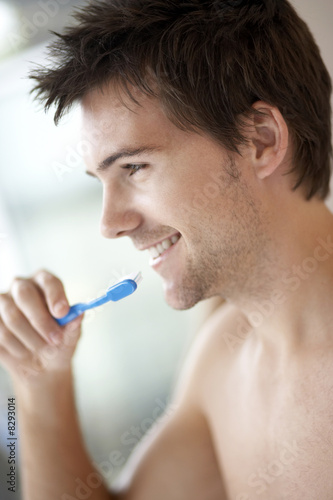 Photo: Young man brushing his teeth, close-up Young man brushing his teeth, close-up
