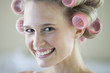 A young woman with her hair in curlers