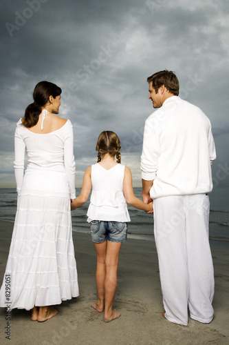 Photo: A couple with their daughter on a beach A couple with their daughter on a beach