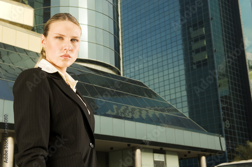 Photo: A businesswoman standing in front of a modern building A businesswoman standing in front of a modern building