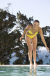 A teenage girl having fun by a swimming pool
