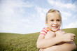 A young girl sitting in a field