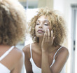 A young woman looking in a mirror