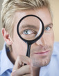 A young man looking through a magnifying glass