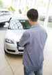A young man looking at a new car