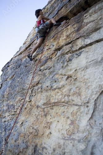 Photo: A climber climbing a rock face A climber climbing a rock face