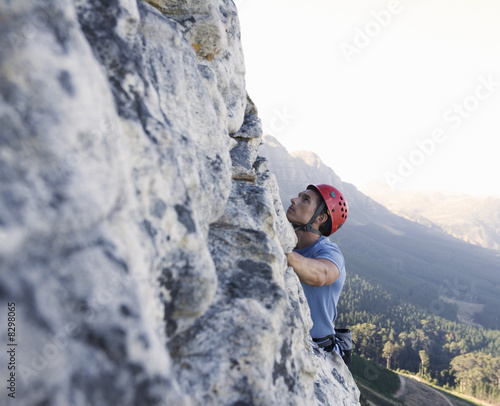 Photo: A climber climbing a rock face A climber climbing a rock face