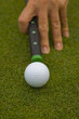 High angle view of a man's hand aiming a golf ball