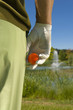 Mid section view of a man standing on a golf course and holding a golf ball