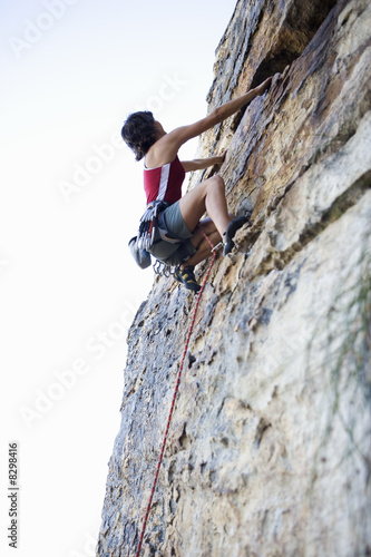 Photo: A climber climbing a rock face A climber climbing a rock face