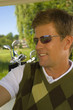 Close-up of a mid adult man in a golf cart and smiling