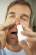 Close-up of a mid adult man using nasal spray