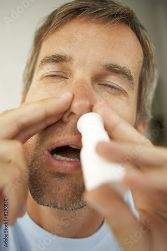 Foto: Close-up of a mid adult man using nasal spray Close-up of a mid adult man using nasal spray