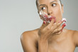 Close-up of a young woman licking her finger covered with cake icing