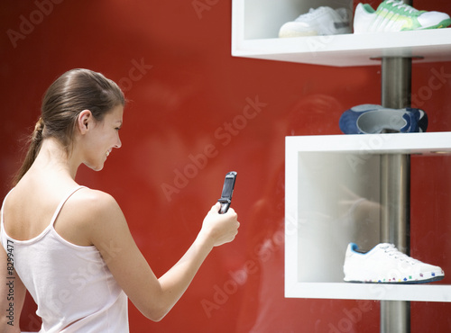 Photo: A young woman looking in a shop window A young woman looking in a shop window