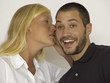 Woman whispering in man's ear