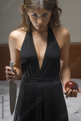 Photo: Intense woman holding knife and apple Intense woman holding knife and apple