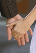 Detail of bride and groom holding hands