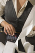 Mid section view of a businesswoman calculating on an adding machine