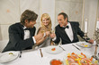 Young couple with a mature man toasting with wine glasses