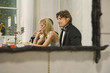Young couple sitting at the dining table reflected in a mirror