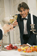 Young man and his friend toasting with wine glasses