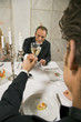 Mature man with his friend toasting with wine glasses