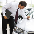 A car salesman polishing a car