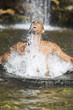 Young man swimming in a natural pool