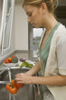 Young woman washing tomatoes