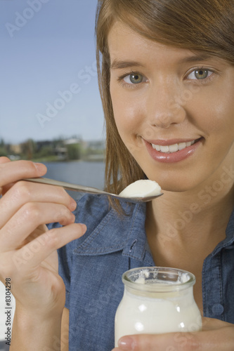 Photo: Young woman eating yogurt Young woman eating yogurt