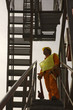 Photo: Low angle view of a male dock worker holding a wrench and standing on a staircase Low angle view of a male dock worker holding a wrench and standing on a staircase