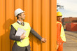 Photo: Male dock worker hiding from a businessman behind a cargo container at a commercial dock Male dock worker hiding from a businessman behind a cargo container at a commercial dock