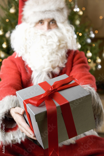 Photo: Father Christmas/Santa Claus holding a present Father Christmas/Santa Claus holding a present