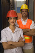 Portrait of two dock workers standing at a commercial dock and smiling