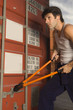 Dock worker cutting the bolt of a cargo container with a bolt cutter