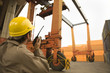 Close-up of a dock worker talking on a walkie-talkie at a commercial dock