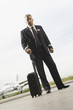 Portrait of a pilot standing holding his luggage