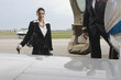 Photo: Portrait of a cabin crew with a pilot standing at the vehicle door of a private airplane Portrait of a cabin crew with a pilot standing at the vehicle door of a private airplane