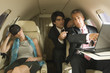 Photo: Two businessmen using a laptop with a businesswoman sleeping wearing a sleep mask Two businessmen using a laptop with a businesswoman sleeping wearing a sleep mask