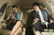 Businessman and a businesswoman sitting in a private airplane