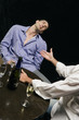 Young man lying unconscious with another young man sitting beside him