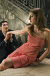 Young man pleading to a young woman on a staircase