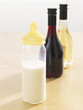 Close-up of a baby bottle with two wine bottles