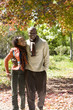 Photo: Couple walking in autumn park, arms around each other, smiling, front view, portrait Couple walking in autumn park, arms around each other, smiling, front view, portrait